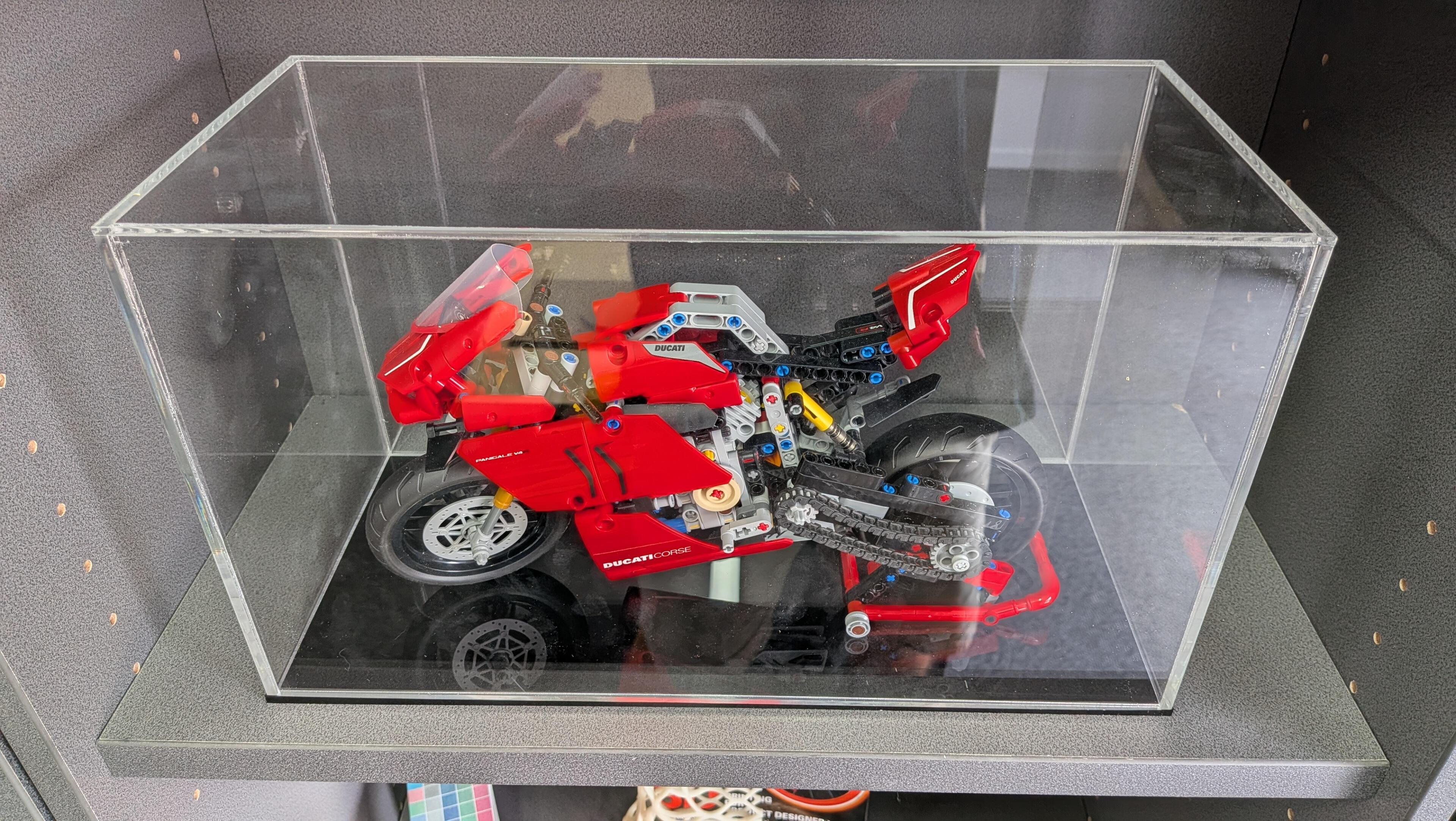 Lego clear acrylic Perspex display case A clear acrylic Perspex display case with a red Ducati motorcycle made from Lego inside